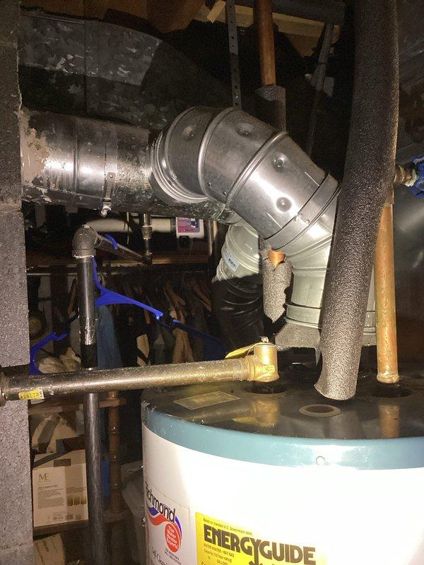 Completed water heater estimate for residential basement installation. Assessed existing white tank-style water heater with proper venting through metallic elbow duct connector, foam-insulated copper supply lines, and brass shut-off valving. Documented current installation configuration including proximity to HVAC furnace unit and available clearances within utility space for potential replacement considerations.