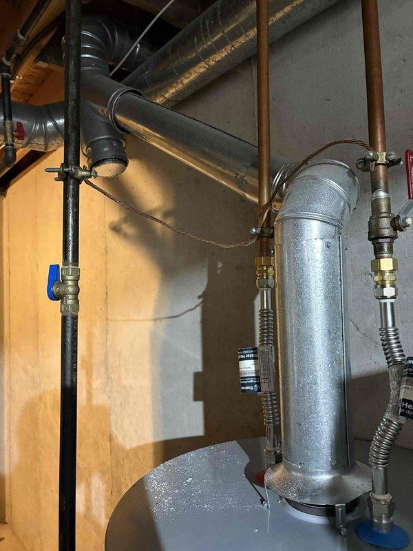 Responded to service call for non-operational water heater that was previously self-installed by customer. Upon arrival, inspected A.O. Smith 100-gallon water heater installation including all plumbing connections, copper supply lines, blue-handled isolation valve, expansion tank mounting, and associated system components. Documented existing installation conditions with photographs showing water heater unit, expansion tank, pipe connections, valve configurations, and overall system setup in basement utility area for diagnostic and record-keeping purposes.