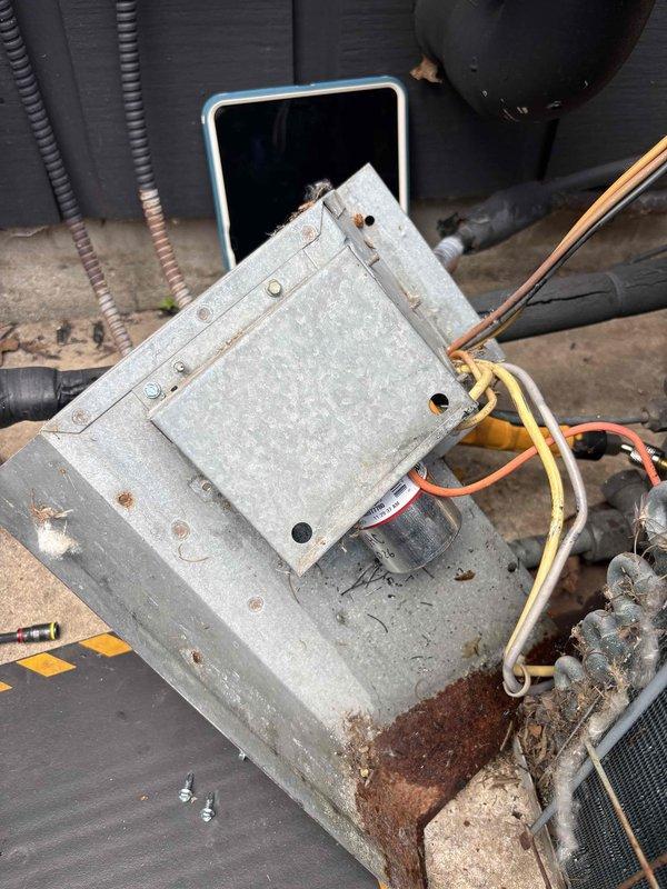 # Cooling System Diagnostic and Repair

Responded to service call for inadequate cooling performance on downstairs 31-year-old Trane split system with condenser manufactured in 2014. Upon arrival, performed comprehensive system evaluation including visual inspection of both indoor air handler and outdoor condensing unit.

Conducted thorough examination of outdoor unit components, identifying signs of extended service life with accumulated dust, dirt, and minor surface corrosion on metal housing and mounting brackets. Inspected electrical connections, capacitor housing, and motor components for proper operation and physical condition. Noted environmental factors including installation in enclosed mechanical space with evidence of age-related wear on equipment surfaces.

Examined outdoor condensing unit electrical control box, observing weathering and rust staining on housing exterior consistent with extended outdoor exposure. Verified integrity of electrical connections and wiring, incl