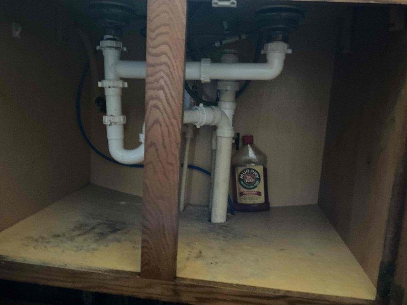 Responded to recurring odor issue from kitchen drain system connected to gray water dry well in 60-year-old home. Inspected under-sink plumbing and P-trap configuration, verified Studer valve operation, and assessed drainage system integrity. Cleaned main drain line to restore proper venting and eliminate sewer gas backup, resolving odor problem that had developed over recent weeks.