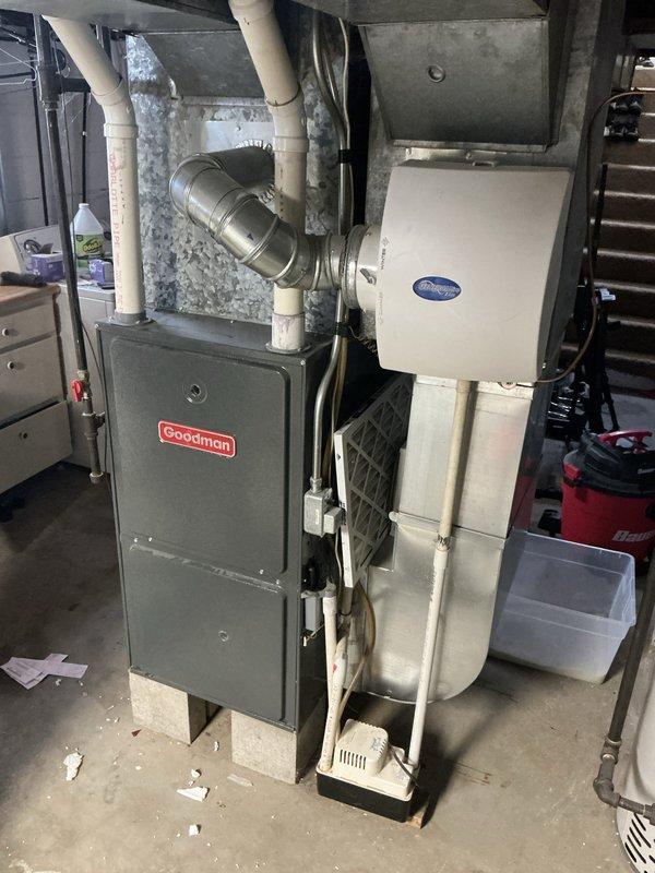 Completed estimate for residential HVAC system experiencing dual equipment issues. Air conditioning unit cycling on and immediately shutting off, indicating potential short cycling problem requiring further diagnostic evaluation. Water heater not heating adequately compared to previous performance levels. Inspected Goodman furnace system and associated air handler equipment in basement mechanical room. Documented existing equipment configuration including ductwork connections, PVC venting system, and current installation setup. Photographed both HVAC components and water heater to assess equipment age, condition, and replacement options for customer consideration.