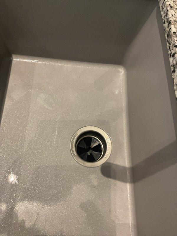 Responded to mother-in-law suite for garbage disposal seizing and leak under sink. Upon inspection, found disposal unit jamming and minor leak at mounting assembly. Freed impeller jam, tested disposal operation, and tightened mounting flange to eliminate leak. Verified proper drainage through P-trap configuration and confirmed all connections secure with no active leaks. Unit restored to full operational status.
