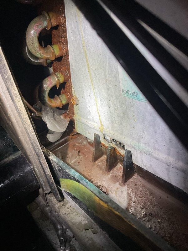 Responded to no cooling call on system installed approximately one year ago. Found unit completely inoperable with continuous water leakage into drain pan despite system being off. Upon inspection, discovered severe corrosion on evaporator coil and drain pan assembly, indicating premature failure. Documented extensive rust damage to mounting hardware and heat exchanger components. System requires evaporator coil replacement and drain pan assembly due to corrosion beyond serviceable limits.