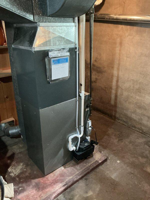 Completed full HVAC system replacement in residential basement utility room. Installed new vertical furnace unit with proper venting configuration using PVC piping for intake and exhaust. Connected condensate drainage system with pump at base of unit. Integrated air handler components and established proper ductwork connections to existing galvanized steel distribution system. Mounted control board and wiring, ensuring all electrical connections meet code requirements. Verified all safety labels and documentation affixed to equipment. System tested and confirmed operational upon completion.