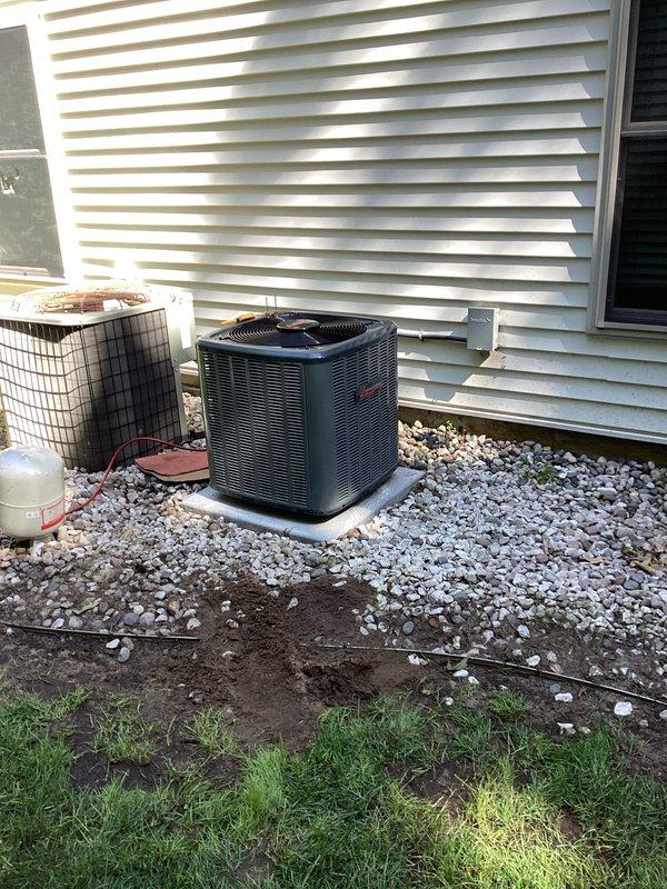 Completed full HVAC system replacement including new air handler installation in basement utility room with proper condensate drain line configuration using white PVC piping, and installed new outdoor condenser unit on gravel pad with concrete base. Removed and disposed of old cylindrical outdoor unit, established proper refrigerant lines, electrical connections via conduit, and verified all mechanical and electrical components are functioning to manufacturer specifications.