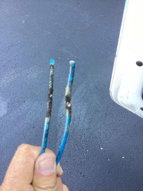 Responded to cooling complaint where 9-year-old air conditioning system ran continuously for 12 hours but only reduced indoor temperature from 84°F to 81°F with inadequate cold air output. Upon inspection, discovered significant accumulation of organic debris including leaves, twigs, and dirt inside outdoor unit compartment, restricting airflow and compromising system efficiency. Identified deteriorated electrical wiring with visible corrosion and heat damage on exposed copper conductors, presenting both a safety hazard and operational failure point. Cleaned debris from unit enclosure, replaced damaged wiring with proper connections, and restored electrical integrity to contactor assembly. Verified system operation and proper cooling performance upon completion.