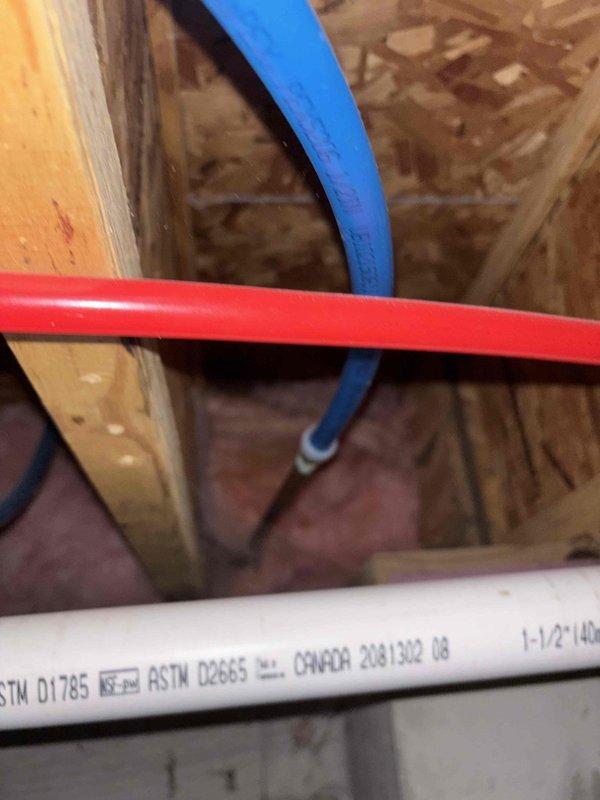Responded to service call for two plumbing issues: outdoor faucet with continuously spinning handle and leaking pipe beneath automatic urinal flush valve in upstairs bathroom. Inspected exterior hose bib mounted on building foundation through vinyl siding—handle exhibited complete rotation indicating stripped stem or seat assembly. Accessed attic crawl space to evaluate urinal supply system; identified leak at connection point below automatic flush valve where PEX supply lines and PVC drain lines converge. Photographed both locations for documentation. Replaced faulty outdoor faucet valve stem assembly and tightened compression fittings. Repaired leaking connection at urinal valve using appropriate sealant and secured all supply line connections. Tested both repairs under full water pressure to confirm proper operation and verify no residual leaks.