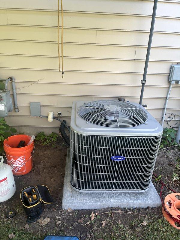 Completed full HVAC system installation including new Carrier brand furnace and air conditioning unit. Furnace installed in basement utility area with proper plenum connections, flexible and rigid ductwork integration, and PVC condensate drainage. Outdoor AC unit positioned on concrete pad against exterior wall with appropriate electrical connections, refrigerant line set, and conduit runs. All equipment mounted securely, tested for proper operation, and verified system functionality upon completion.
