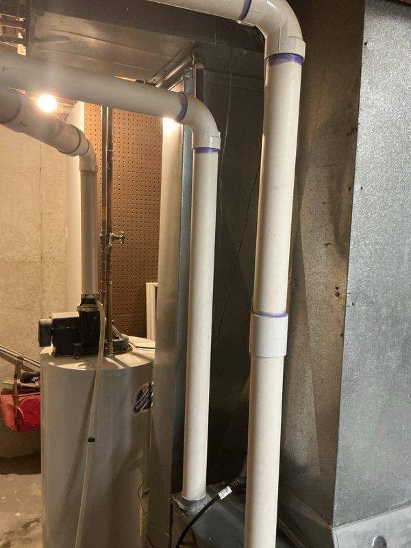 Responded to service call for non-operational air conditioning system. Upon arrival, conducted thorough inspection of residential HVAC installation located in basement mechanical room. System consists of gray metal furnace unit with associated water heater, copper refrigerant lines, and white PVC intake/exhaust venting. Performed diagnostic assessment of equipment to identify cause of cooling failure. Documented existing installation configuration including furnace positioning, ductwork connections, and venting arrangement. Photographed equipment layout and current system condition for estimate preparation. Provided customer with comprehensive estimate for necessary repairs to restore air conditioning functionality.