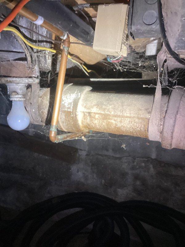 Conducted comprehensive plumbing evaluation of 1929-era residential property following home inspection findings. Assessed multiple plumbing valves requiring replacement throughout the home, examining both supply and drainage systems in basement and crawlspace areas. Documented existing conditions including aged PVC drainage piping with mineral deposits and discoloration at joints, gray pressure tank or filter housing components, and various copper supply lines with associated fittings. Evaluated insulated mechanical equipment, electrical connections, and utility infrastructure in confined access areas beneath the structure. Photographed all plumbing components, valve locations, and system configurations to provide detailed estimate for necessary repairs and replacements identified during the inspection process.