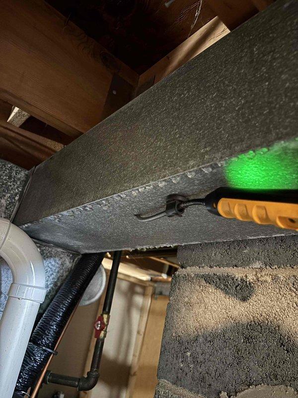 Responded to no cooling complaint at recently purchased home with unknown system history. Upon inspection, discovered significant condensation on supply ductwork and extensive dust/debris accumulation throughout mechanical space indicating poor airflow and possible insulation issues. Inspected attic/crawl space ductwork using diagnostic lighting to assess insulation condition and identify potential air leakage points. System evaluation revealed temperature differential concerns likely caused by combination of restricted airflow from debris buildup and inadequate duct insulation allowing heat gain. Documented conditions with photographic evidence showing moisture accumulation on metallic ductwork surfaces and contaminated surrounding areas requiring attention to restore proper cooling performance.