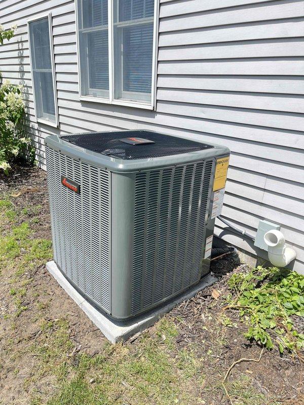Completed full HVAC system installation including new furnace and air conditioning unit. Installed Trane outdoor condensing unit on concrete pad with proper condensate drainage via PVC piping mounted to exterior wall. Installed new furnace in basement mechanical room with associated white PVC venting routed through ceiling, copper refrigerant lines, and floor-level condensate drainage connections. All equipment positioned per manufacturer specifications, properly wired, piped, and tested for operational readiness.