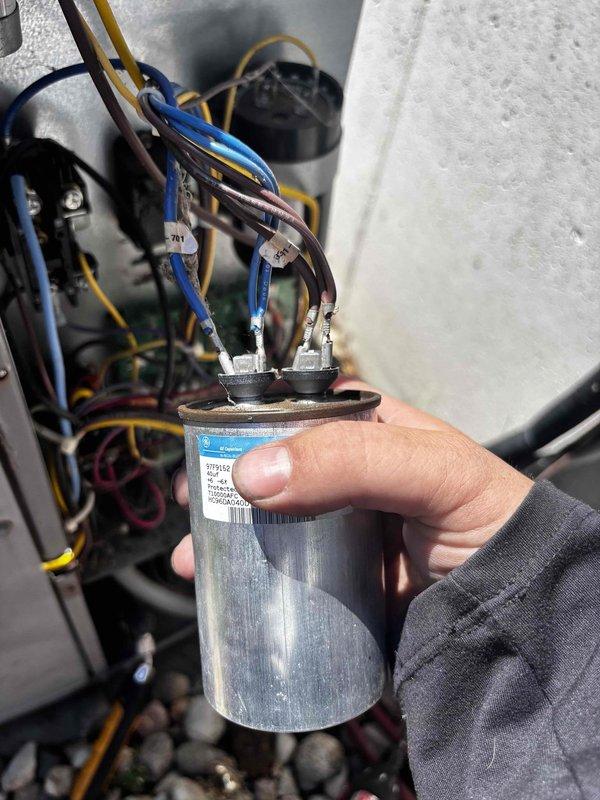# Carrier Air Conditioner No Cooling - Capacitor and Wiring Repair

Responded to service call for 10-year-old Carrier air conditioning system with complete loss of cooling affecting entire residence. Upon arrival, performed system diagnostics and visual inspection of outdoor condensing unit electrical components.

Inspection revealed failed dual-run capacitor with visible deterioration and compromised wire connections. Further examination identified damaged brown wire conductor with burned and frayed insulation near capacitor terminal connection, indicating electrical arcing or overheating condition. Wire damage showed exposed conductor with heat-affected areas and compromised insulation integrity.

Removed defective capacitor from electrical compartment and disconnected all associated wiring. Repaired damaged wire conductor by cutting back to undamaged section and installing new terminal connector. Verified all remaining wire connections for signs of heat damage or loose terminals.

I