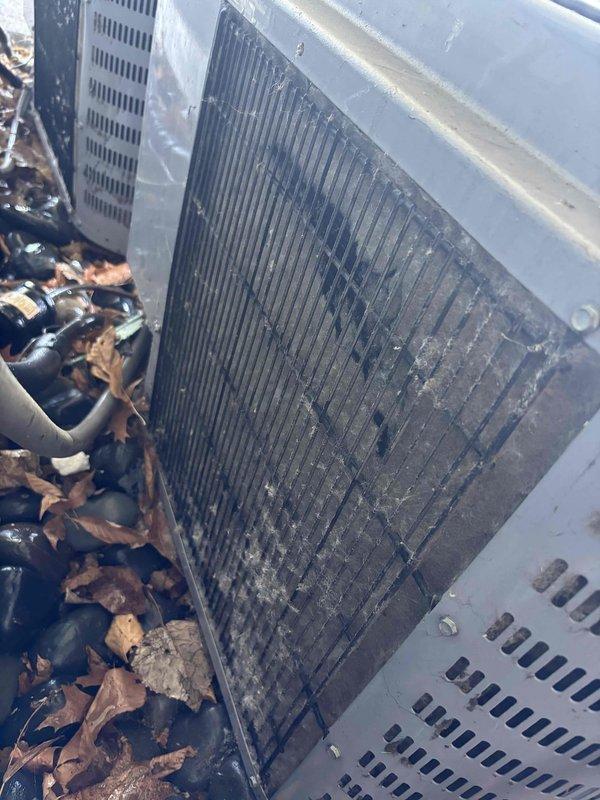 # CP-Cooling Problem Resolution

Responded to no-cooling complaint on 2017 Heil air conditioning system. Upon arrival, performed visual inspection of outdoor condensing unit and found heavily soiled condenser coil with significant accumulation of dust, debris, and environmental contaminants restricting airflow. Noted substantial leaf debris around unit base contributing to reduced system performance.

Cleaned condenser coil thoroughly to restore proper heat transfer capability and airflow through fins. Removed accumulated leaves and debris from around unit perimeter and base to prevent future airflow obstruction. Verified system operation and confirmed unit restored to proper cooling functionality. System now operating within normal parameters.