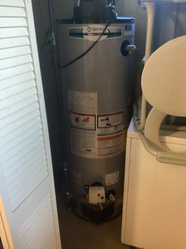Completed water heater tune-up service on AO Smith gas water heater installed in utility closet of 72-year-old residential home. Performed complete tank flush to remove sediment buildup, inspected all plumbing connections and supply lines for signs of corrosion or rust concerns noted by homeowner, verified proper venting operation, and tested TPR valve functionality. All components found operating within normal parameters with no immediate safety concerns identified.