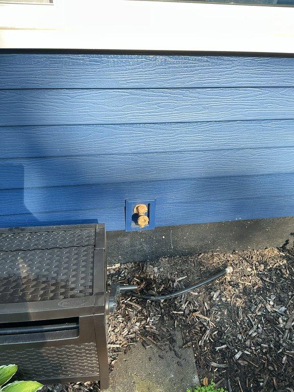 Replaced exterior hose spigot on blue-sided building foundation as quoted. Completed installation with copper fittings in recessed access panel, addressing water damage concerns evident on adjacent weathered deck surface.