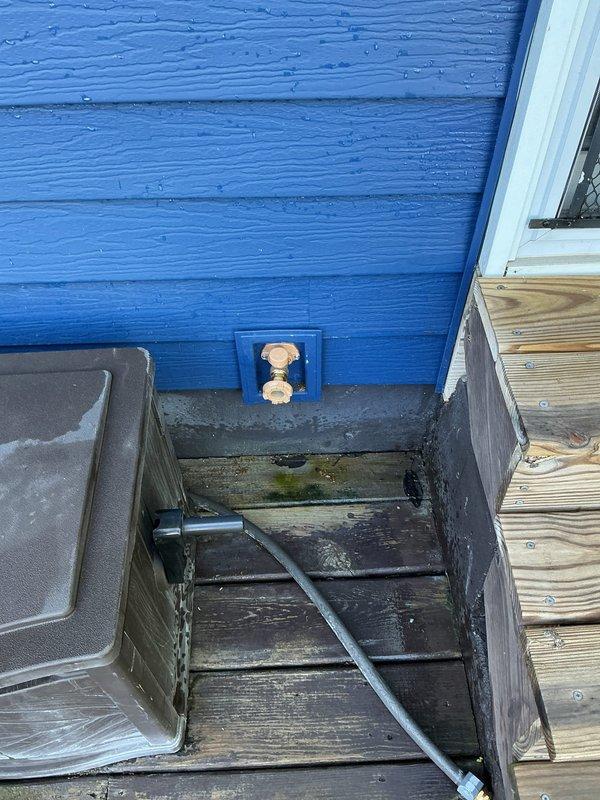 Replaced exterior hose spigot on blue-sided building foundation as quoted. Completed installation with copper fittings in recessed access panel, addressing water damage concerns evident on adjacent weathered deck surface.