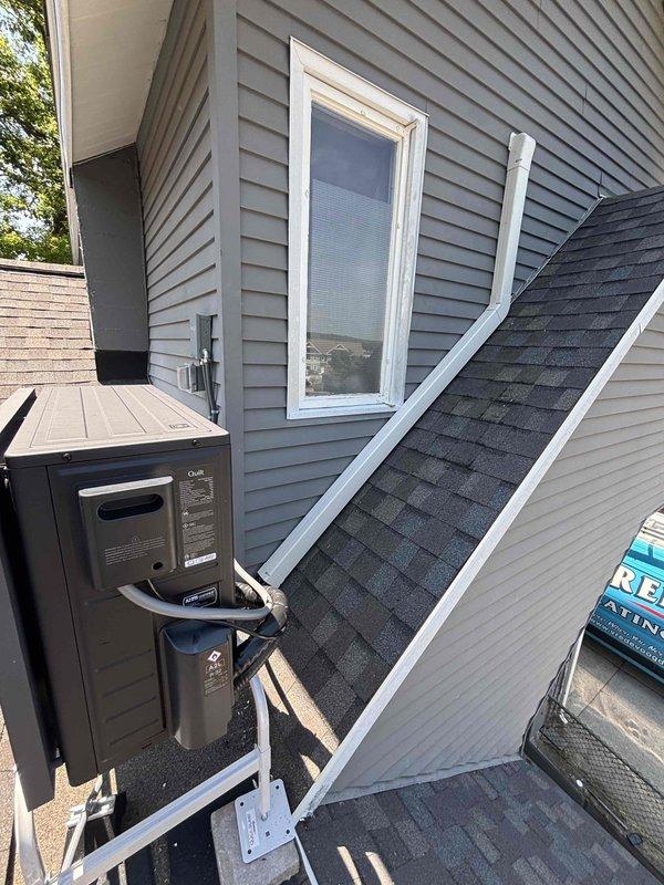 Completed installation of ductless mini-split system including exterior condenser unit mounted on exterior wall with gray vinyl siding and interior wall-mounted air handler unit installed in mudroom area. Refrigerant lines and electrical connections were run between outdoor condenser and indoor evaporator unit, with PVC condensate drain line installed along exterior wall. System was tested and verified operational upon completion.