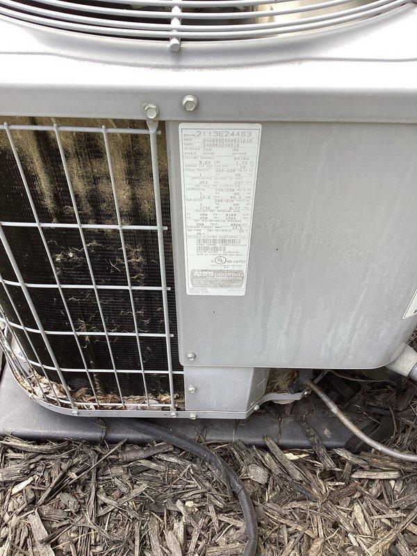 # No Cool Service Call - Outdoor AC Unit

Responded to no cooling complaint on residential air conditioning system. Upon arrival, found outdoor condenser unit with heavily soiled condenser coils showing significant dirt, dust, and debris accumulation restricting airflow. Unit appears to be 10+ years old based on condition and wear patterns.

Performed visual inspection of outdoor unit which revealed substantial contamination on protective coil grille requiring cleaning for proper heat exchange. Refrigerant lines and electrical conduits secured at top of unit with cable ties appeared intact. Unit nameplate indicates model number 2113E24483.

Accessed indoor air handler to inspect electrical controls and wiring connections. Found control board with multiple wire terminations in somewhat disorganized condition. Inspected all wire connections including blue, brown, black, yellow, orange, pink, white, gray, and tan conductors for proper termination and signs of overheating or failure. Contr