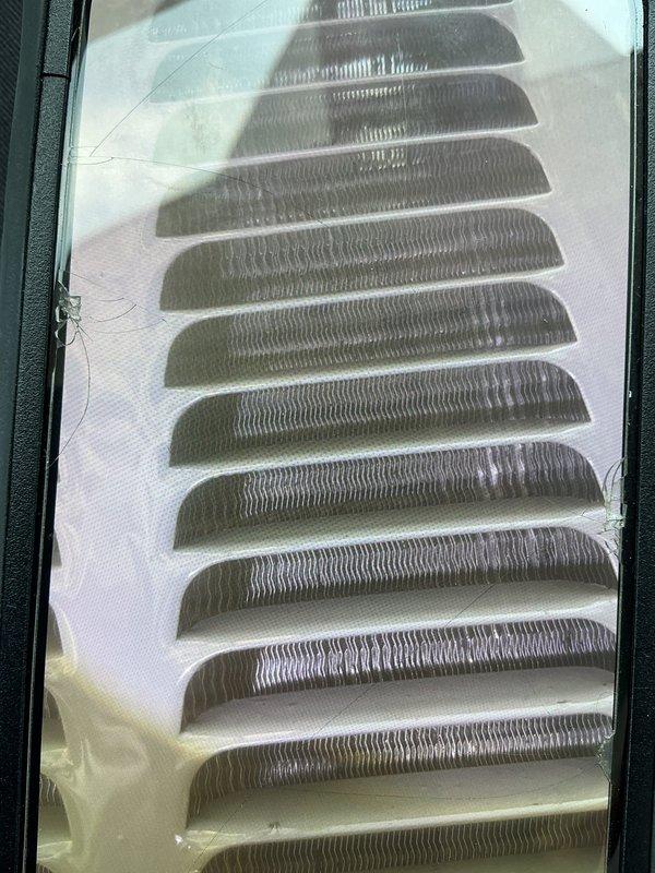 Responded to cooling complaint on 13-year-old EnergiAir system with reduced cooling capacity affecting entire home. Upon inspection, examined evaporator coil assembly and air distribution components, documenting condition of heat exchanger fins and ventilation grille. System evaluated for airflow restrictions and component performance to determine cause of diminished cooling output.