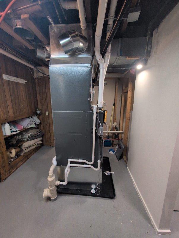 Successfully completed full HVAC system installation in basement mechanical room, including new furnace and air conditioning unit. Installed vertical air handler with proper platform mounting, connected metallic supply ductwork with appropriate elbow fittings extending to distribution points throughout the structure, and completed white PVC condensate drainage piping with necessary joints and routing to floor drain. All ductwork secured at ceiling level with proper support, system tested for operational functionality, and installation area left clean and ready for service.