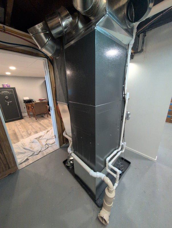 Successfully completed full HVAC system installation in basement mechanical room, including new furnace and air conditioning unit. Installed vertical air handler with proper platform mounting, connected metallic supply ductwork with appropriate elbow fittings extending to distribution points throughout the structure, and completed white PVC condensate drainage piping with necessary joints and routing to floor drain. All ductwork secured at ceiling level with proper support, system tested for operational functionality, and installation area left clean and ready for service.