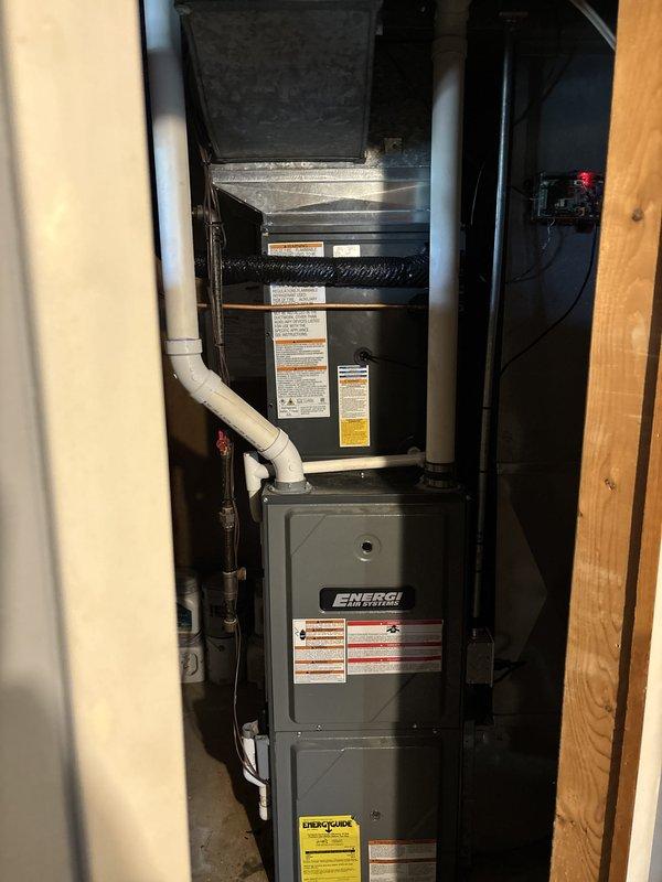 Complete HVAC system replacement performed, including installation of new air handler unit and furnace assembly in interior utility space, along with outdoor condensing unit. Interior components installed in vertical stack configuration with proper ductwork connections, electrical integration, and PVC condensate drainage routing. Outdoor condensing unit positioned on concrete pad with electrical disconnect box mounted to exterior wall and conduit properly run. All units branded ENERGI AIR SYSTEMS with appropriate manufacturer labels, specification plates, and EnergyGuide documentation affixed. System tested and verified operational upon completion.
