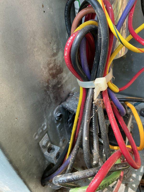 Responded to no cooling complaint on main floor air conditioning system. Upon arrival, inspected 14-18 year old Goodman unit and found electrical connection issues at the outdoor unit. Examined contactor, wiring connections, and electrical components within the condenser panel. Wiring showed signs of age with dust accumulation and environmental wear. Secured loose wire connections, cleaned electrical contacts, and verified proper voltage at contactor. Tested system operation and confirmed unit returned to normal cooling function.