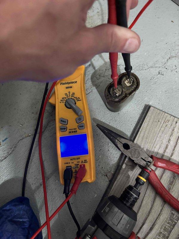 Responded to no cooling complaint on 23-year-old Lennox system with inadequate upstairs cooling while downstairs remained comfortable. Upon inspection, located Lennox refrigerant evaporator (Model C23-41-1) utilizing HCFC-22 refrigerant with heavy condensation present on equipment surfaces, indicating active refrigeration cycle. Performed diagnostic testing of electrical components using digital multimeter to verify capacitor functionality and system electrical integrity. All readings confirmed proper capacitor operation and electrical performance within manufacturer specifications. System age and differential cooling between floors suggests potential airflow imbalance, ductwork issues, or zoning concerns requiring further evaluation. Equipment operational at time of service.