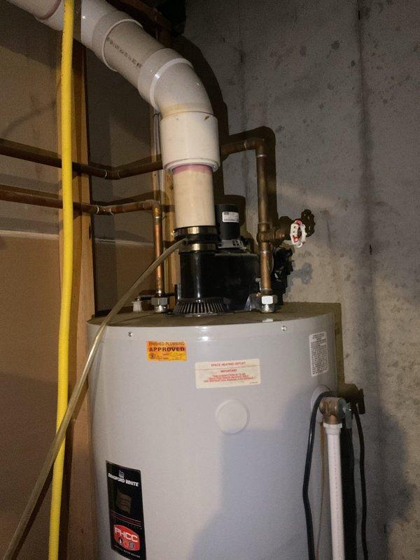 Responded to service call for leaking water heater. Upon arrival, inspected 24-year-old Bradford White water heater installation in basement utility area. Confirmed active leak from aging tank unit. Documented existing system configuration including copper supply and return piping, circulator pump assembly mounted at top of tank, PVC venting system, and all associated valves and connections. Photographed current installation showing water heater positioned against concrete wall with complete plumbing infrastructure. Provided comprehensive estimate for replacement of failed water heater unit with new equipment to restore hot water service and eliminate leak condition.