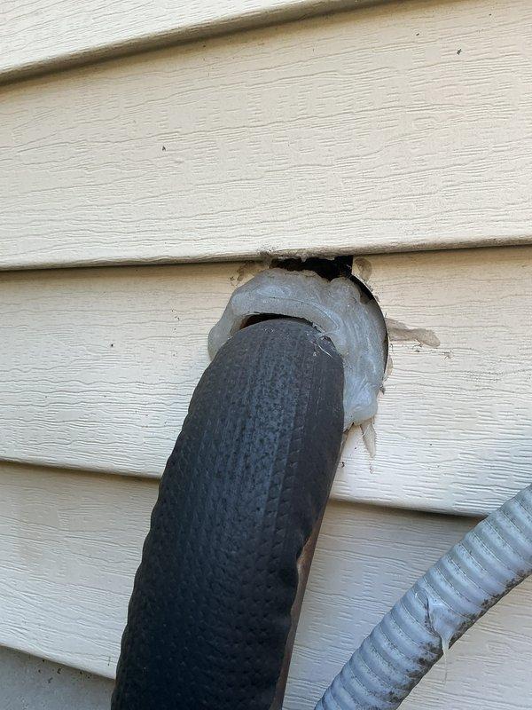 Completed annual AC tune-up on 2022 Energi Air system under 5-year warranty coverage. Performed standard maintenance inspection including condenser coil cleaning, refrigerant level verification, and electrical component testing. Documented exterior line set penetration point showing siding deterioration around refrigerant lines requiring future attention, and photographed condenser coil fins showing normal operational wear and surface oxidation but maintaining adequate airflow capacity.