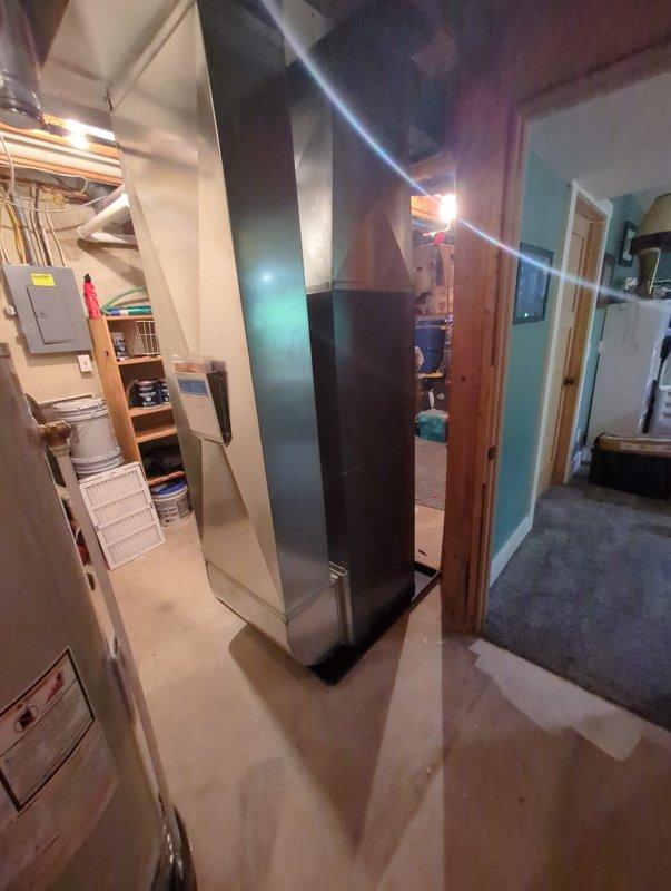 Completed full installation of new furnace and air conditioning system. Equipment installed in basement utility area with proper venting through vertical flue pipe extending floor to ceiling. All ductwork, refrigerant lines, and electrical connections completed to manufacturer specifications. Gas meter connections verified at exterior location with copper piping properly routed along building exterior. System tested and operational upon completion. Payment collected on site.