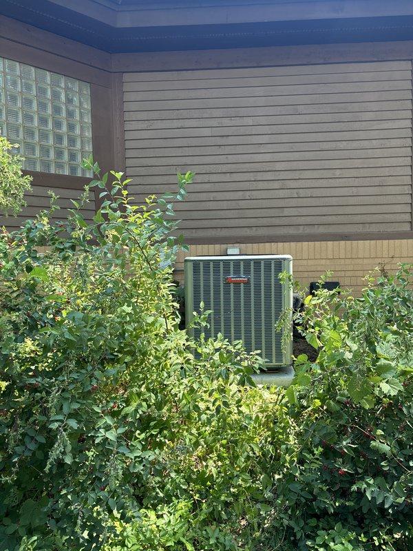 Completed full residential air conditioning system replacement at exterior location. Installed new condenser unit on existing concrete pad against building exterior, routed electrical conduit and wiring to dual disconnect boxes mounted on siding, verified all electrical connections and proper unit operation. System tested and operational upon completion.