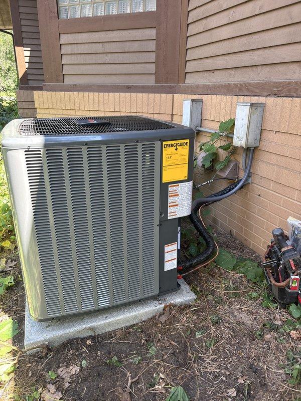 Completed full residential air conditioning system replacement at exterior location. Installed new condenser unit on existing concrete pad against building exterior, routed electrical conduit and wiring to dual disconnect boxes mounted on siding, verified all electrical connections and proper unit operation. System tested and operational upon completion.