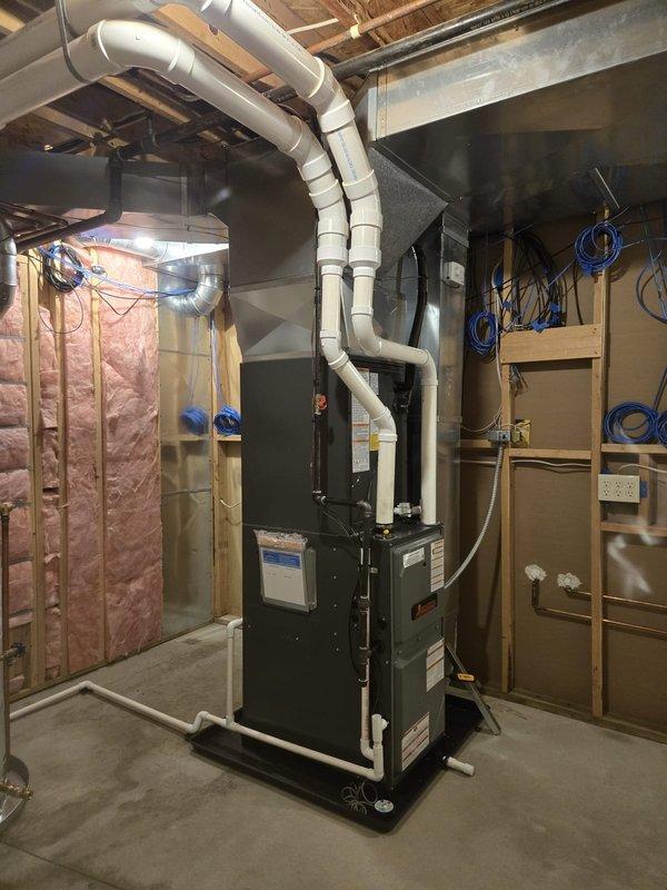 Completed full system replacement including furnace, air conditioning unit, and water heater at residential property. Installed new furnace unit with proper PVC venting routed through basement ceiling joists, positioned water heater adjacent to furnace in utility closet with appropriate metallic flex connections, and configured all condensate drainage lines with white PVC plumbing. All equipment mounted on platform base, ductwork professionally routed and secured, and systems tested for proper operation upon completion.