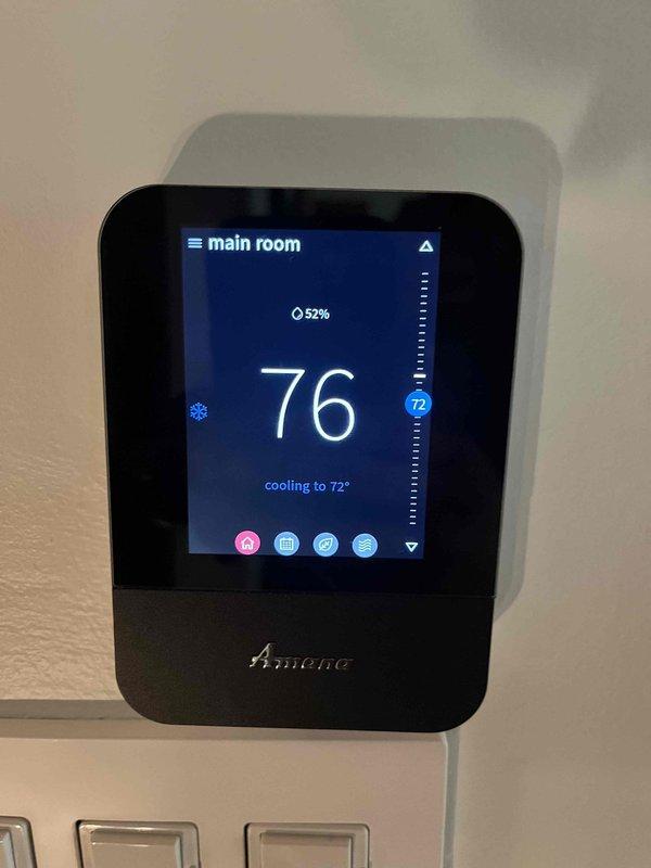 Completed annual cooling maintenance and tune-up on residential AC system. Addressed customer concerns regarding existing Amana smart thermostat displaying inaccurate temperature readings in main room, with current reading showing 76° while cooling to setpoint of 72°. Inspected thermostat wiring installation and noted low-voltage cables routed through exposed wall cavity near floor transition area. Performed standard preventative maintenance procedures on cooling equipment and documented system operation with photos. Discussed thermostat replacement options with customer to resolve accuracy issues.