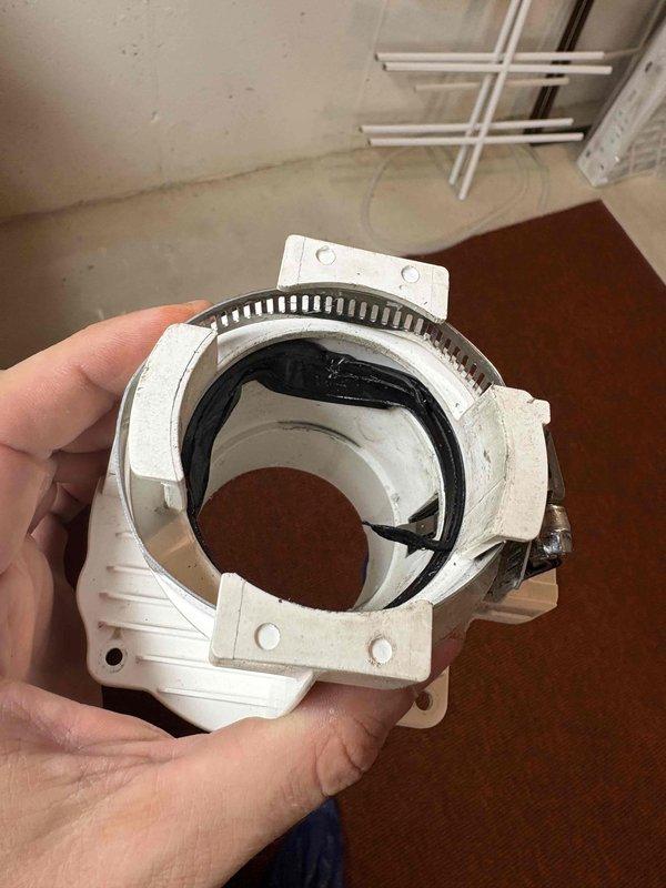 Responded to emergency no-hot-water call for tankless water heater system. Upon inspection, identified failed exhaust vent gasket causing improper seal at the termination assembly. Removed deteriorated gasket and hose clamp from white plastic exhaust housing adapter. Installed new gasket with proper hose clamp to restore airtight seal and ensure safe venting operation. System tested and verified proper operation with no exhaust leaks detected.