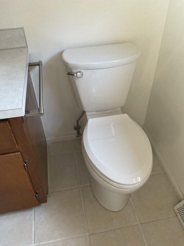 Successfully completed installation of comfort height elongated toilet in bathroom corner location. Installed new two-piece toilet with chrome flush lever, connected water supply line using braided stainless steel flexible supply hose, and verified proper operation and seal integrity upon completion.