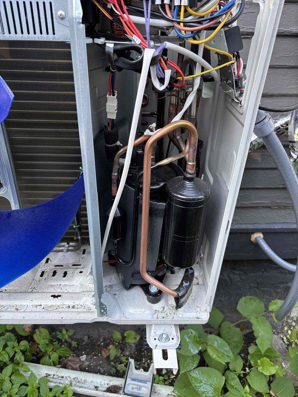 # CP-Cooling Problem Resolution

Responded to service call for residential air conditioning system with complete loss of cooling affecting entire home. Unit was approximately six months old with no prior service history.

Upon arrival, performed visual inspection of outdoor condensing unit and indoor air handler components. Examined electrical connections, capacitor assembly, compressor operation, and refrigerant line configuration. Inspected control board wiring, verified proper wire terminations with numbered connectors, and assessed overall system installation quality.

Conducted diagnostic assessment of blower motor assembly, capacitor housing, and associated electrical components within air handler cabinet. Evaluated copper refrigerant line routing and connections for proper installation and potential restrictions. Photographed key system components including outdoor unit internals showing compressor, condenser coil, electrical control panel with color-coded wiring harnesses, and 