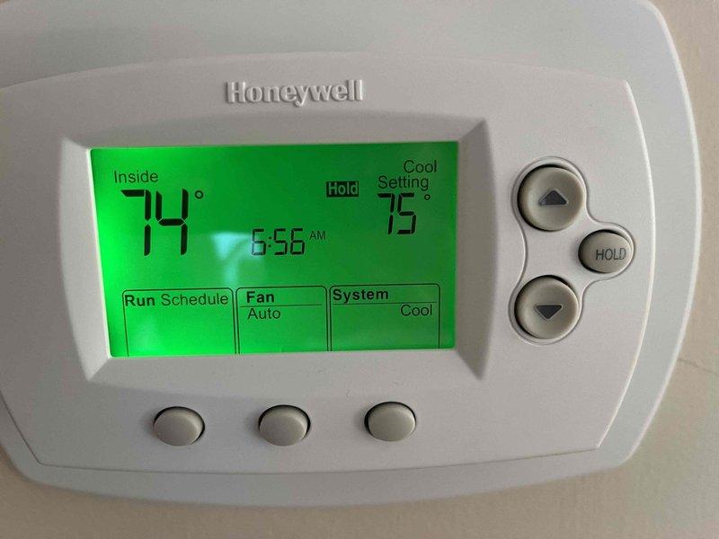 Completed annual cooling maintenance on residential HVAC system including inspection of furnace, air handler, and thermostat operation. Verified Honeywell programmable thermostat functioning properly with system in cooling mode at 75° setpoint, confirmed proper airflow through ductwork and filter accessibility, and documented equipment condition with photos showing all components operating within normal parameters.