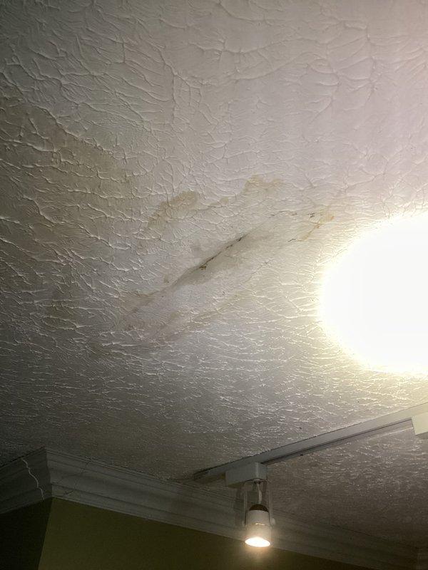 Responded to report of ceiling crack with mold growth initially suspected to be foundation-related. Upon inspection, identified active water staining on textured ceiling with brownish discoloration indicating moisture intrusion from plumbing system above. Documented conditions including water damage patterns on ceiling surface and secondary moisture indicators on bathroom floor tiles showing discoloration and staining. Confirmed plumbing leak as source of ceiling damage rather than structural foundation issue. Photographed affected areas for documentation and recommended follow-up plumbing repairs to address leak source and subsequent mold remediation of damaged ceiling materials.