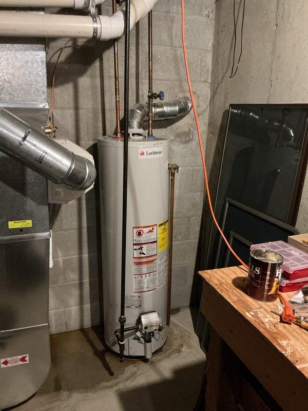 Responded to water leak complaint with puddle forming on basement floor during AC operation. Upon arrival, found 26-year-old Heil air conditioning system with clogged condensate drain line causing water to overflow onto concrete floor. Cleared blockage from condensate tube using appropriate methods to restore proper drainage flow. Verified system cooling performance remained unaffected and operational. Tested drain line for proper water discharge and confirmed no further leakage occurring. System returned to normal operation with condensate draining correctly through cleared line.