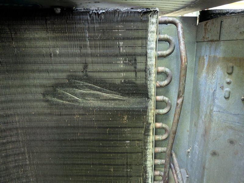 Responded to no cooling complaint on 23-year-old system. Upon inspection, found evaporator coil heavily contaminated with dust and debris buildup, restricting airflow through the air handler unit. Documented condition of dirty coil fins and refrigerant lines showing age-related discoloration. Communicated findings regarding system performance issues caused by lack of maintenance and recommended proper cleaning to restore cooling capacity.