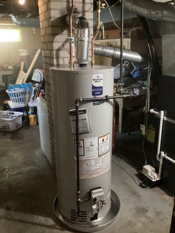 Installed a 50-gallon natural gas water heater with 10-year tank and 10-year parts warranty in basement utility room. Ran new copper supply lines, connected gas line, and installed chimney liner system with new galvanized flue cap assembly on existing brick chimney to ensure proper venting and code compliance.