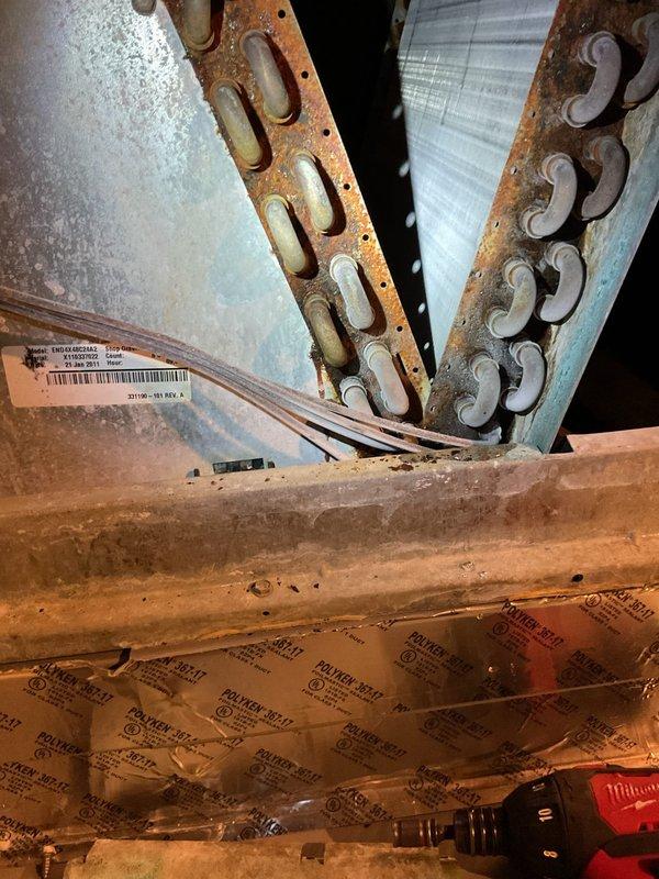 # NC-No Cool Service Completed

Responded to service call for 23-year-old residential air conditioning system experiencing intermittent cooling and freeze-up conditions. Upon arrival, performed comprehensive system evaluation including visual inspection of both indoor air handler and outdoor condensing unit.

Interior inspection revealed significant corrosion and rust deterioration on air handler cabinet components and metal framework, indicating prolonged moisture exposure and potential airflow restrictions. Documented condition of internal components showing advanced age-related degradation consistent with unit's service life.

Exterior examination of condensing unit showed equipment positioned in landscaped area with adequate clearance, though vegetation management may be required for optimal airflow. Unit casing and grille appeared intact with no obvious external damage.

**Diagnosis:** System freeze-up typically caused by restricted airflow, refrigerant issues, or failed component
