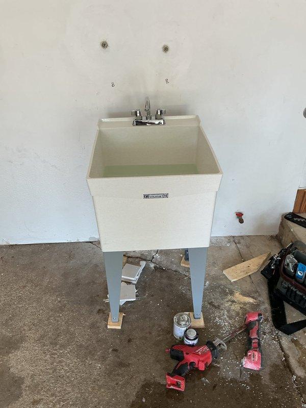 Completed installation of new laundry sink with chrome faucet and replaced three frost-free exterior spigots. The utility sink was mounted on metal legs with proper supply line connections using braided stainless steel hoses and chrome shut-off valves, along with PVC drain piping installed to code.