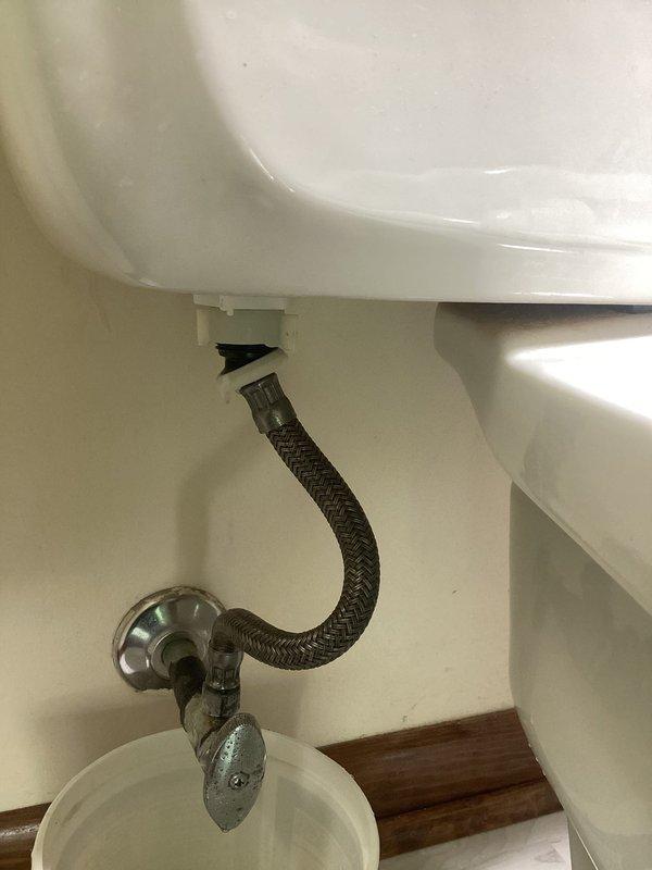Responded to active toilet leak in main bathroom of 77-year-old home where water supply had been shut off by occupant. Upon inspection, identified leak source and assessed toilet condition along with supply line and shut-off valve connections. Evaluated whether repair was viable or full toilet replacement would be necessary given age of fixture and home. Inspected braided stainless steel supply line, chrome shut-off valve, and all connection points for signs of deterioration or failure. Documented existing installation including toilet base seal, floor flange condition, and overall fixture integrity. Verified no additional plumbing issues present in surrounding areas. Photographed toilet installation, supply line configuration, and plumbing connections for record. Provided assessment and recommendations for resolution of leak issue.