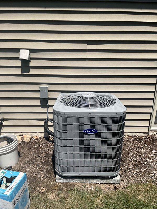 Completed full HVAC system installation including new Carrier outdoor condensing unit and indoor furnace with integrated air handler. Positioned exterior condenser on concrete pad with proper electrical disconnect and refrigerant line connections. Installed indoor equipment in basement utility area with metallic ductwork, insulated refrigerant lines, and proper plenum connections to existing duct system. All components secured, labeled, and operational upon completion.