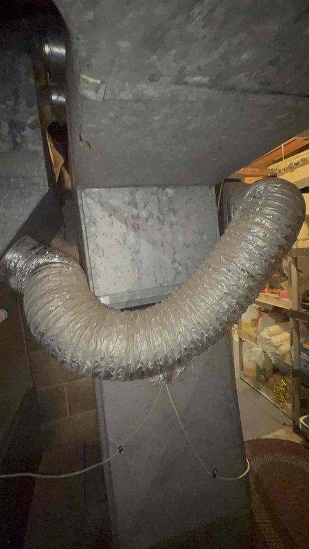 Responded to service call for HVAC system producing buzzing noise and causing electrical interference with household lights. Upon inspection, found 36-year-old Lennox unit with inadequate cooling performance and persistent buzzing that remained unresolved following recent electrical work. Documented existing furnace installation and ductwork configuration in basement utility area. Photographed equipment setup including flexible metallic ductwork, PVC venting system, and gas line connections to assess overall system condition and identify potential electrical or mechanical failure points causing the reported symptoms.