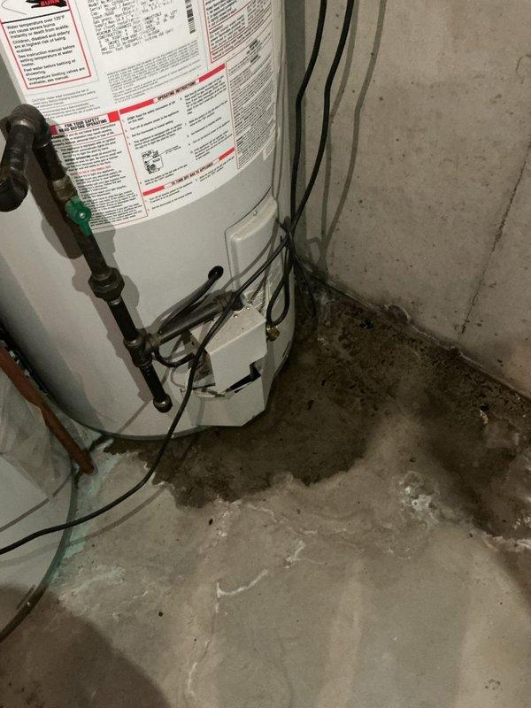 Responded to emergency service call for 20+ year old Bradford White water heater with active leak onto basement floor and inadequate water heating. Upon arrival, found extensive water damage and staining on concrete floor surrounding unit base, confirming active leak. Inspection revealed severely corroded pipes with heavy oxidation throughout the system, consistent with age of equipment. Documented existing conditions including deteriorated piping, water damage patterns, and electrical connections to Siemens panel. Unit assessed as end-of-service-life with multiple failure points requiring replacement rather than repair due to age and extent of deterioration.
